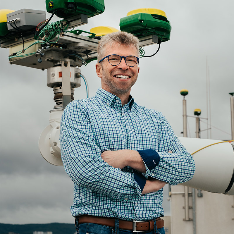 Kormann standing by a robotic arm.